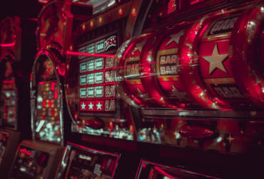 A close-up of a slot machine with BAR symbols and bright red lights